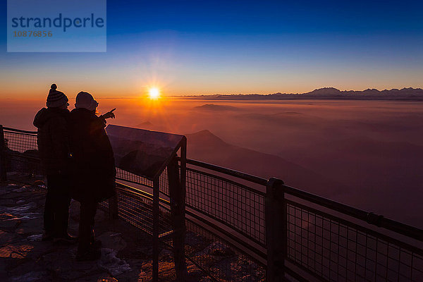 Senioren-Wanderpaar mit Blick auf den Nebel des Bergtals bei Sonnenuntergang  Monte Generoso  Tessin  Schweiz