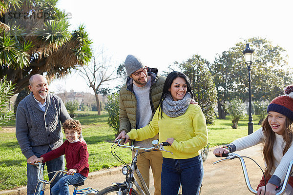 Mehrgenerationen-Familie im Park mit Fahrrädern