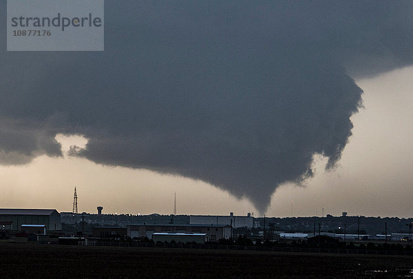 Ein kegelförmiger Tornado stürzt von einer sehr grossen Mauerwolke herab  als er Dodge City  Kansas  USA  bedroht