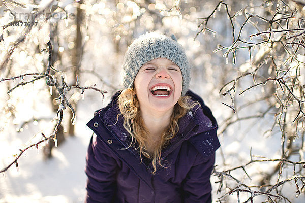 Porträt eines lachenden jungen Mädchens in verschneiter Landschaft