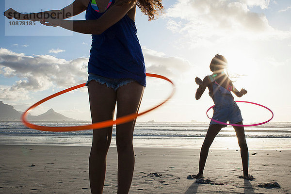 Junge Frauen am Strand mit Hula-Hoop-Reifen