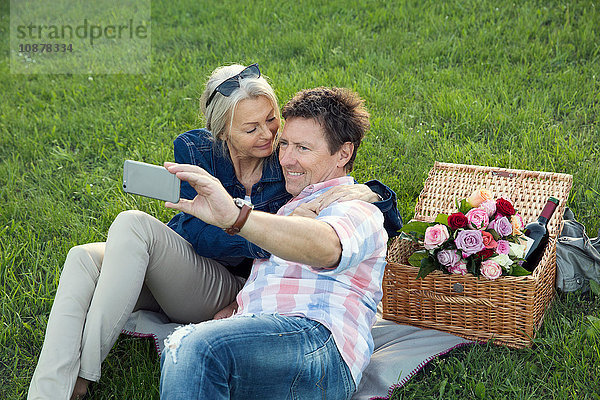 Reifes Paar auf Rasen beim Picknick  Selbsthilfe