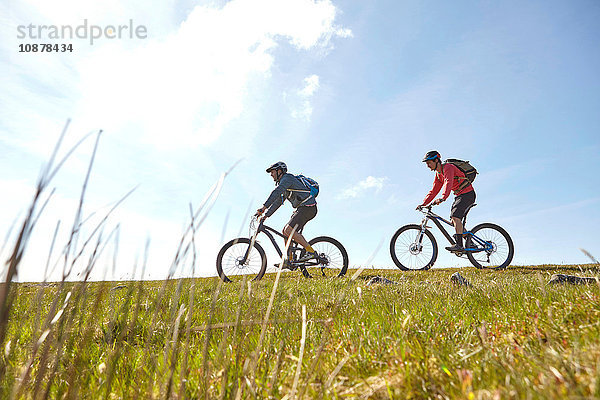 Seitenansicht von Radfahrern  die am Hang fahren