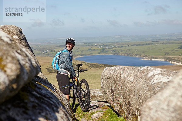 Radfahrer mit Fahrrad auf Felsvorsprung