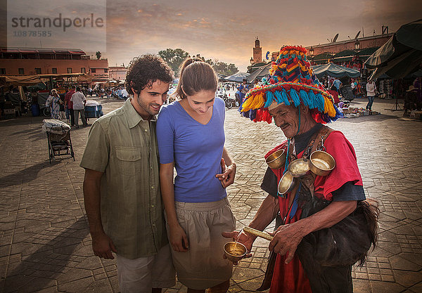 Junges Paar im Gespräch mit einem Markthändler  Jemaa el-Fnaa-Platz  Marrakesch  Marokko