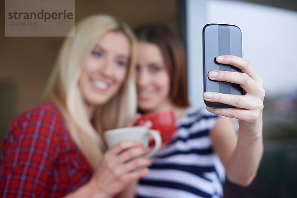 Zwei Freundinnen  Kaffee trinken  im Freien  Selbstporträt mit dem Smartphone