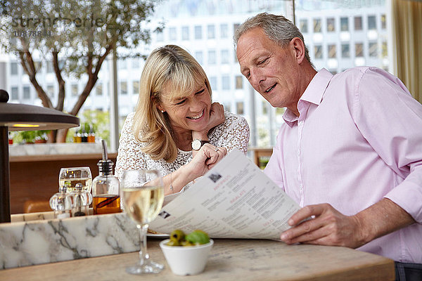 Reifes Dating-Paar liest Speisekarte am Restauranttisch
