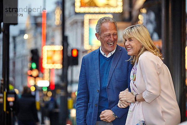 Reifes Dating-Paar kichert in der Abenddämmerung auf der Straße in der Stadt  London  UK