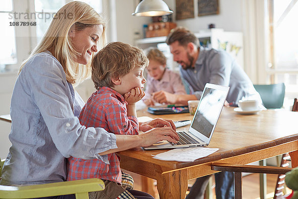 Im Home Office arbeitende Eltern und Söhne