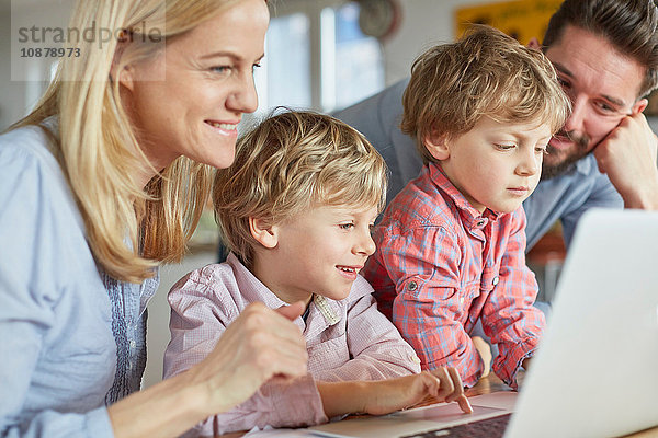 Eltern und Söhne mit Laptop