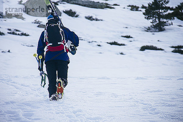 Man with skis and backpack walking in snow