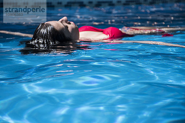 Woman floating on water of a swimming pool