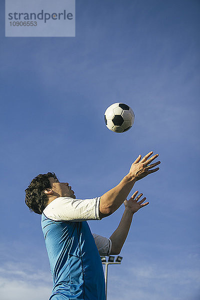 Football player with ball in the air