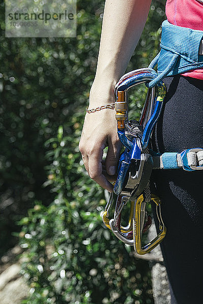 Climbing equipment in the harness of a climber woman