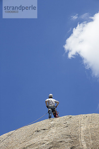 Climber standing on the top of a rock