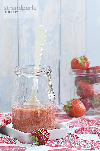 Glass of strawberry smoothie and strawberries