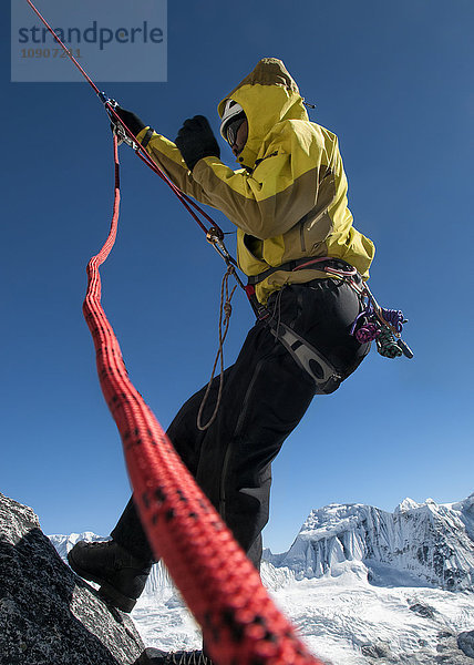 Nepal  Himalaya  Solo Khumbu  Everest-Region Ama Dablam  Bergsteiger mit Seil an der Felswand
