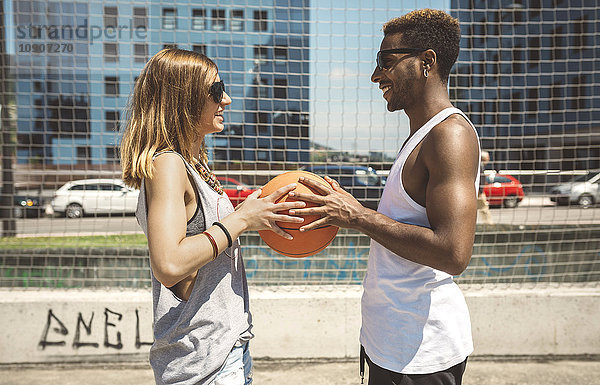 Junges Paar hält Basketball
