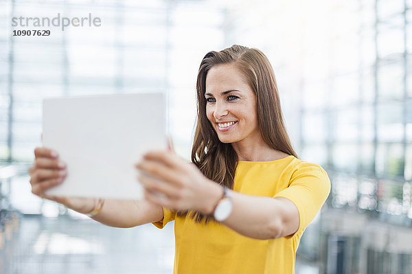 Lächelnde brünette Frau mit digitalem Tablett
