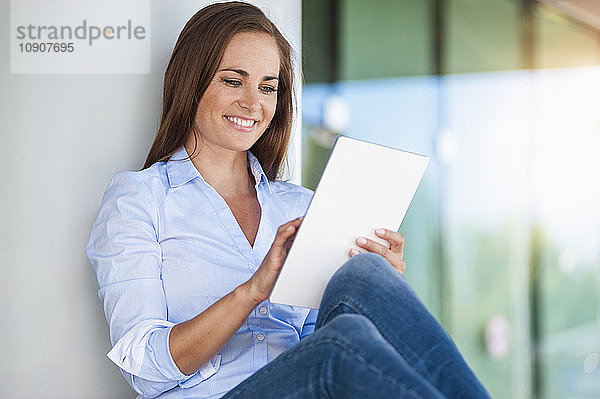 Smiling brunette woman using digital tablet
