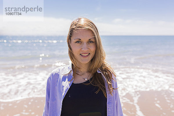 Portrait of smiling young woman at seaside