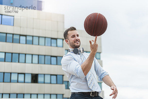 Businessman playing basketball outdoors