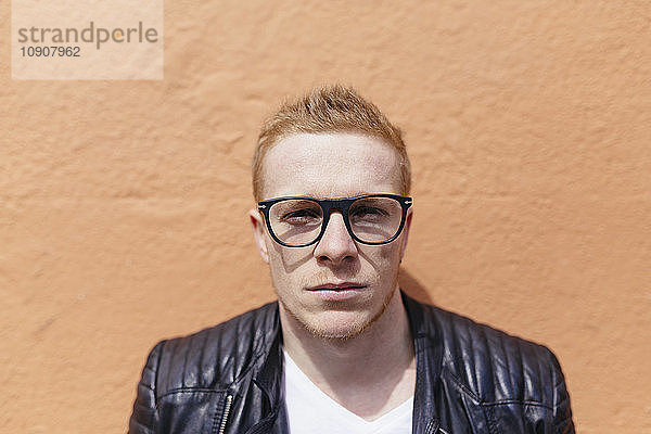 Portrait of strawberry blonde young man wearing black glasses