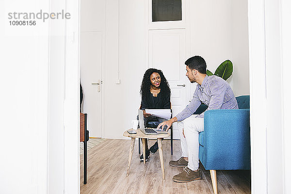 Young business people working relaxed on couch