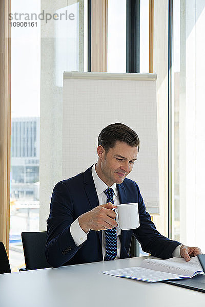 Businessman at office desk reading document