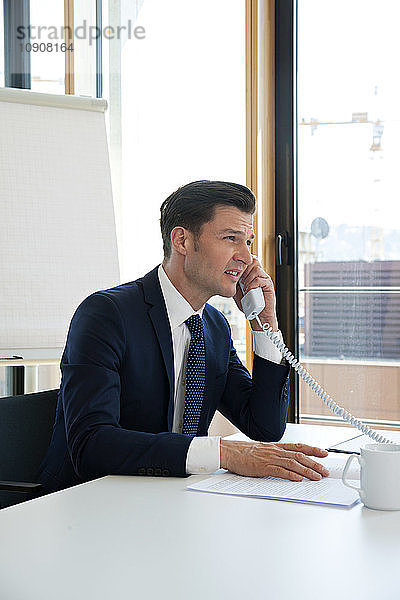 Businessman at office desk on the phone