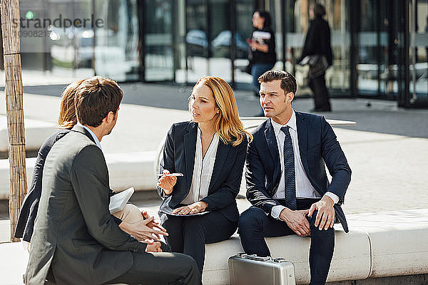 Business colleagues talking outside office building