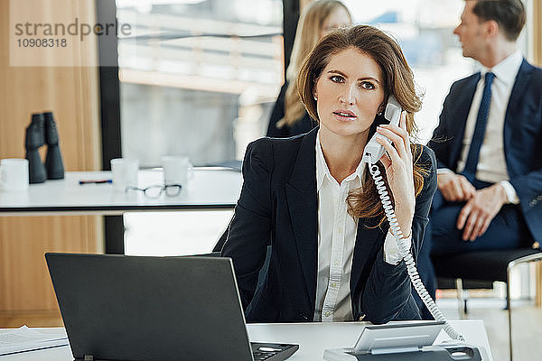 Businesswoman at office desk on the phone
