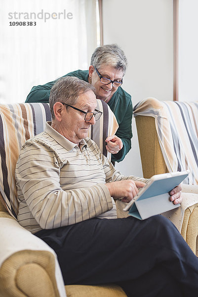 Seniorenpaar zu Hause mit digitalem Tablett