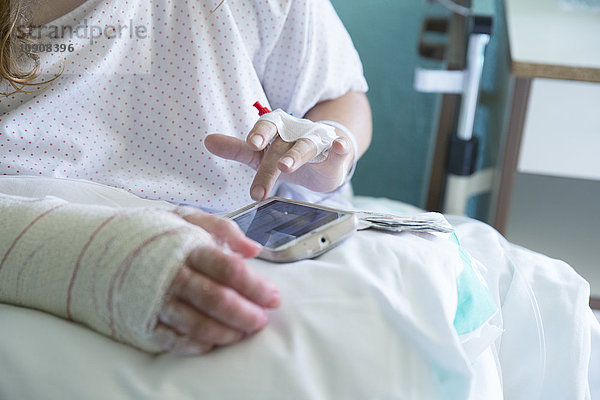 Frau im Krankenhaus  operierte Hand  mit Handy  linke Hand