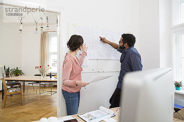 Man and woman discussing plan in office