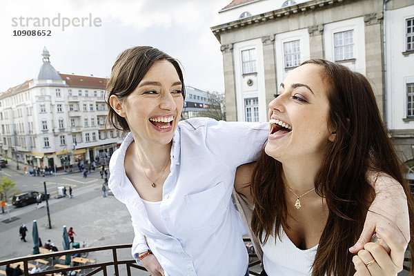 Zwei glückliche Frauen auf dem Balkon