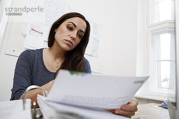 Woman working on files at office desk