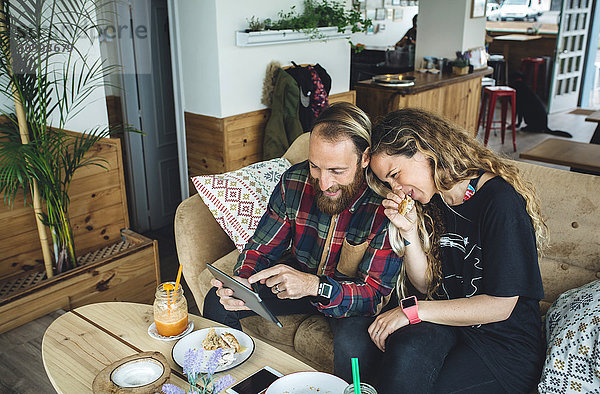 Paar beim Frühstück im Cafe  Blick auf Tablet PC