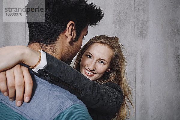 Couple in front of concrete wall