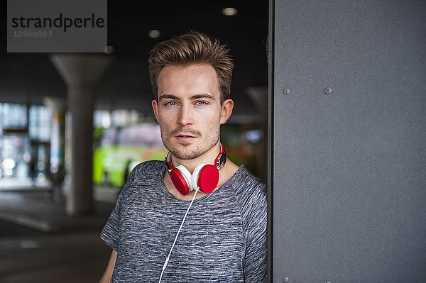 Portrait eines jungen Mannes mit roten Kopfhörern