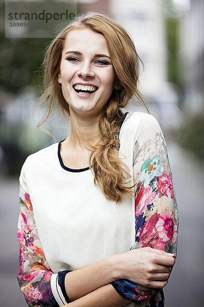 Porträt der lachenden jungen Frau im Freien
