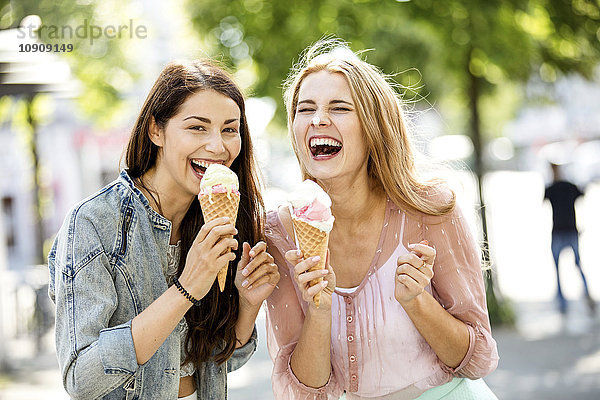 Zwei lachende junge Frauen mit Eistüten