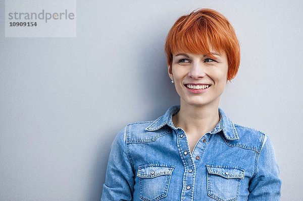 Porträt einer lächelnden rothaarigen jungen Frau