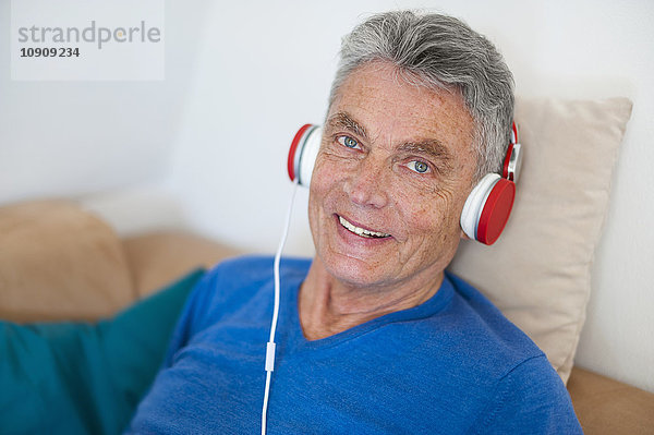 Porträt eines lächelnden älteren Mannes mit Kopfhörer