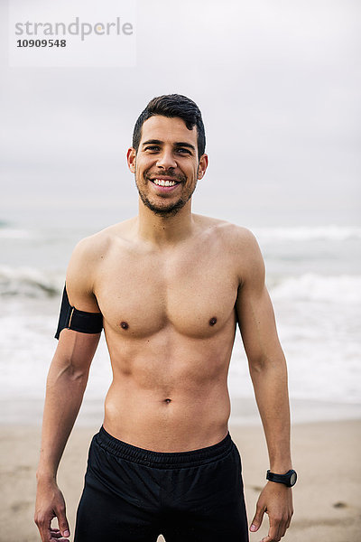 Porträt eines lächelnden Sportlers am Strand