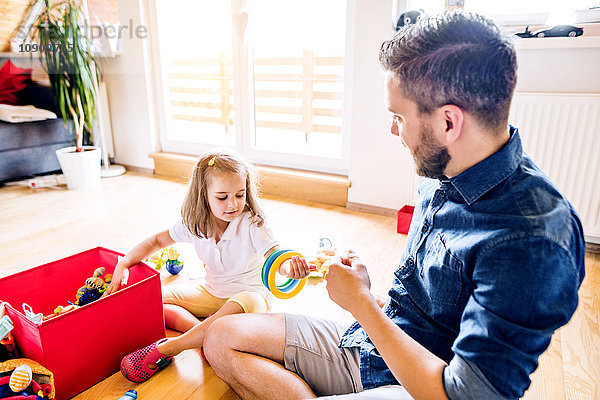 Vater und Tochter spielen zusammen mit Spielzeug