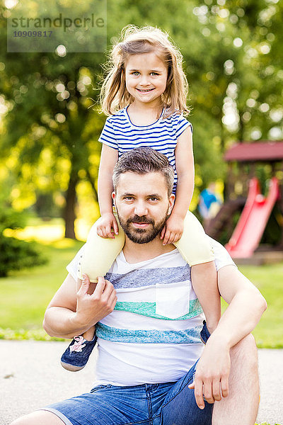 Porträt des Vaters mit kleiner Tochter auf den Schultern