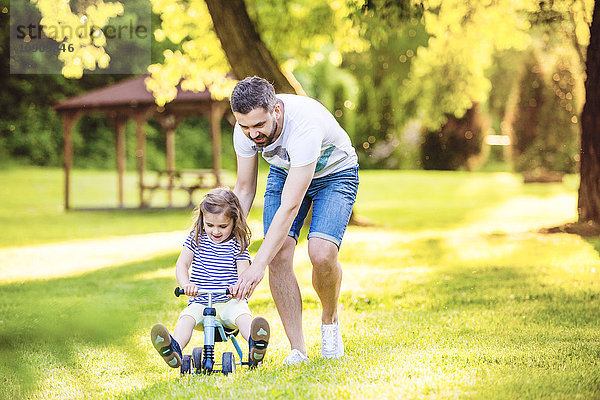 Vater und seine kleine Tochter mit Spielzeugauto im Park