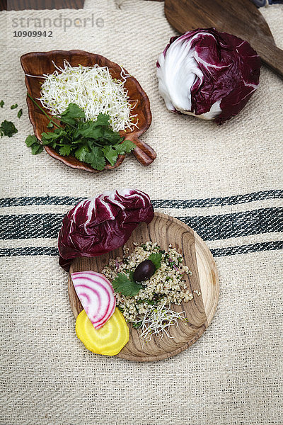 Quinoa-Salat  Radicchio  Rote Beete  gelb und rot auf Holzplatte
