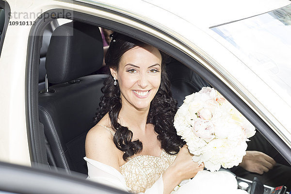 Lächelnde Braut im Auto